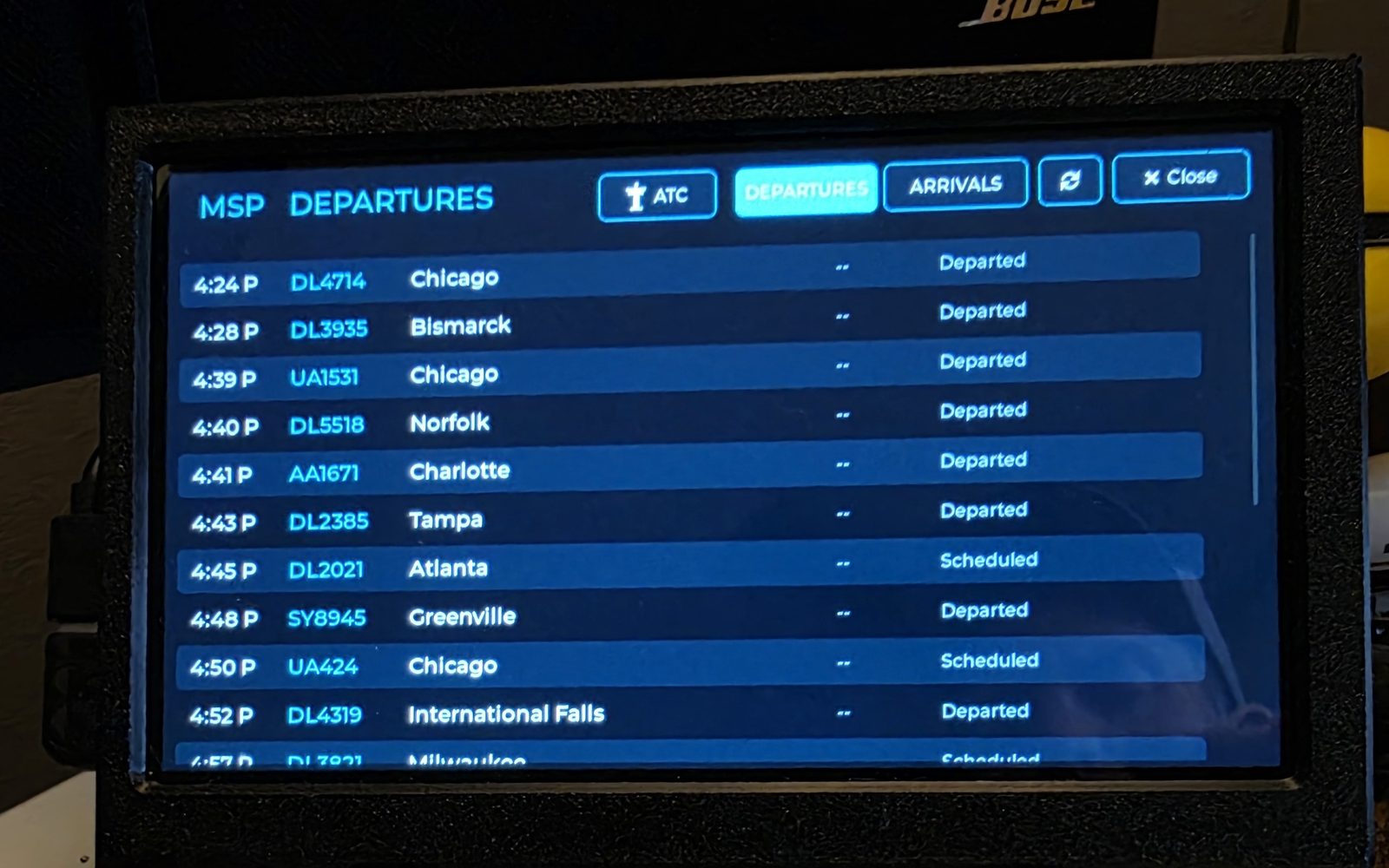 WingsAbove MSP departures board with live times, flight numbers, destinations including Chicago, Bismarck, Tampa and International Falls, and departed or scheduled status