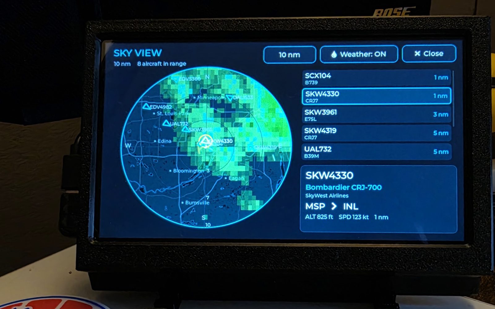 WingsAbove Sky View showing eight aircraft in range on a full-screen radar with live weather overlaid and a distance-sorted aircraft list